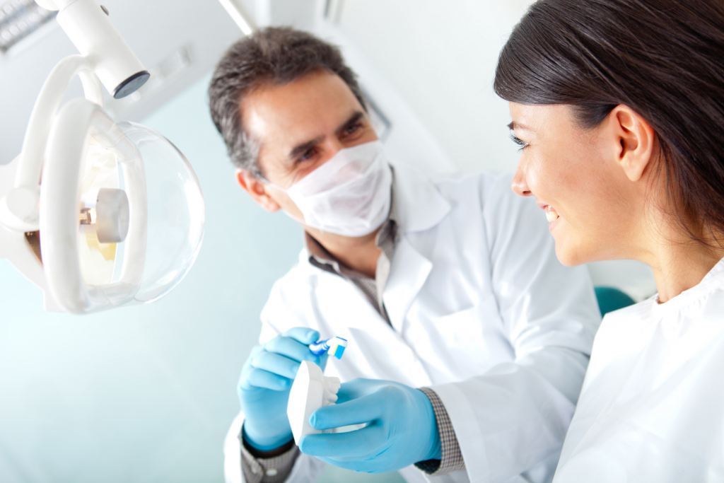 dentist_male+dentist+with+toothbrush+talking+to+patient-5616x3744